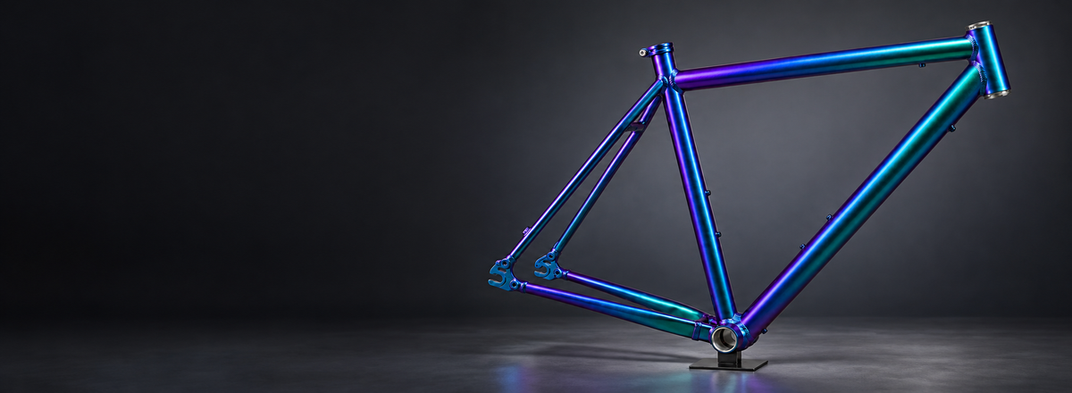Marco metálico de bicicleta con acabado tornasol violeta, azul y turquesa, en una composición panorámica del servicio de pintura Chaskicleta.