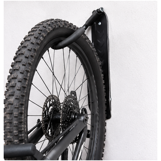 Detalle del colgador negro instalado en pared sujetando una rueda de bicicleta